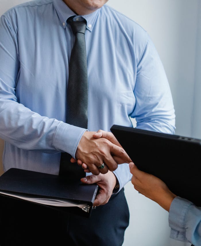 Home Business handshake between colleagues in a formal office meeting setting.
